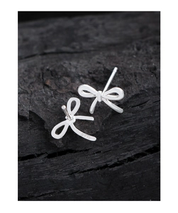Vue macro des boucles d'oreilles nœud en argent S925 avec finition polie et poinçon