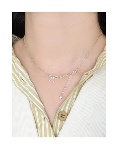 Gros plan du collier en argent sterling S925 avec pendentif nœud délicat et breloque cœur