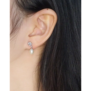 Boucles d'oreilles fleur en argent S925 avec perles d'eau douce blanches sur modèle