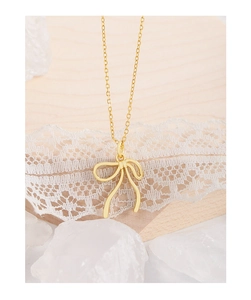 Gros plan détaillé du pendentif nœud doré exposé sur un présentoir à bijoux en bois élégant