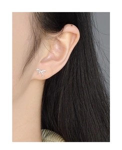 Gros plan de boucles d'oreilles nœud minimalistes en argent S925 portées par un mannequin