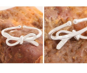 Detail shot of the S925 hallmark on the silver bow ring against a stone background
