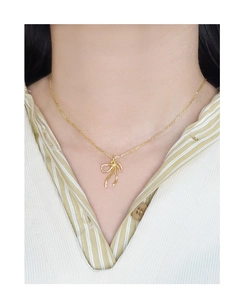 Gros plan d'un collier doré élégant avec pendentif nœud porté par un mannequin