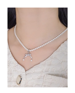 Dettaglio della collana con ciondolo a fiocco in argento S925 e perle indossata