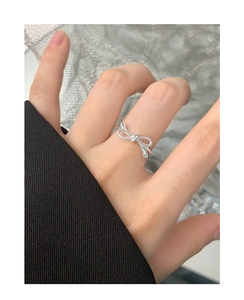 Detailed close-up of a 925 sterling silver bow ring worn on a finger