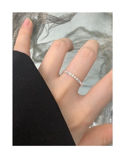 Gros plan d'une bague minimaliste en argent S925 avec trois perles portée sur le doigt