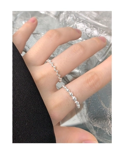 Macro shot of S925 sterling silver beaded rings stacked on finger for women