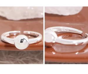 Macro detail of S925 sterling silver stamp and polished ball on an open ring