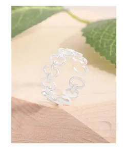 Macro detail of S925 sterling silver chain ring on wooden base with greenery
