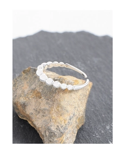 Macro shot of S925 sterling silver beaded ring on natural stone with adjustable band