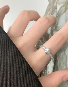 Close-up of minimalist S925 sterling silver ring with a polished metal ball design