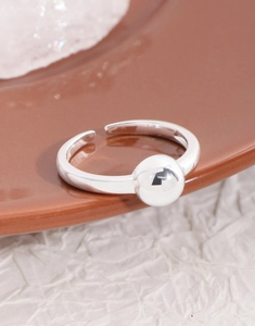 Macro shot of silver polished ball on a minimalist adjustable open ring band
