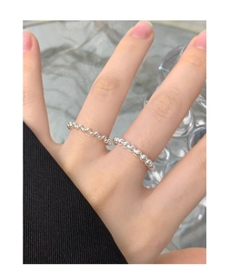 Detailed view of two 925 sterling silver beaded rings worn on model fingers