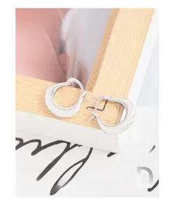Detailed view of irregular U-shaped S925 sterling silver earrings with polished mirror finish