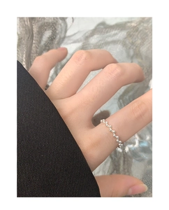 Macro detail of a 925 sterling silver beaded wave ring with polished sphere texture