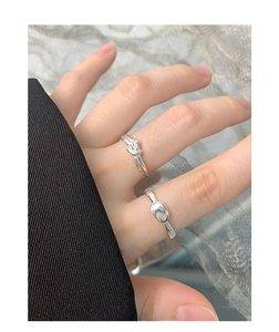 Detail view of S925 sterling silver knot and bean rings worn with fashion attire