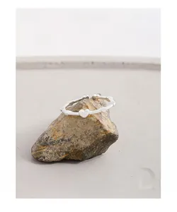 Macro detail of S925 sterling silver heart ring with bamboo joint band on stone