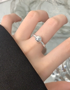 Close-up of minimalist S925 silver ring featuring a polished metal ball on a woman's hand
