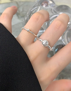 Detailed close-up of a minimalist S925 silver double ring set with metallic spheres