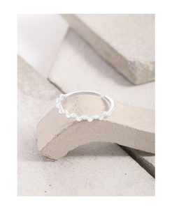 Close-up of S925 sterling silver beaded open ring on textured stone surface