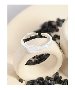 Macro detail of silver S925 lava ring with pebble design on ceramic display