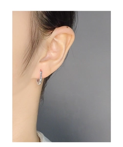 Close-up of minimalist S925 sterling silver irregular U-shaped hoop earring on ear