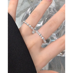 Minimalist S925 sterling silver beaded ring shown worn on finger with glass background