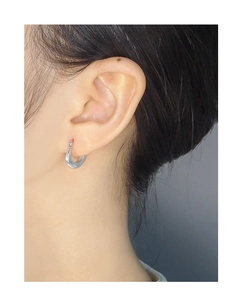 Close-up of minimalist S925 sterling silver U-shaped hoop earring on model ear