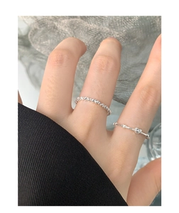 Detail of S925 sterling silver heart ring and beaded band worn on fingers