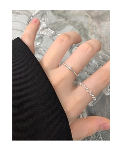 Detail of S925 sterling silver beaded ring and minimalist band on a female hand