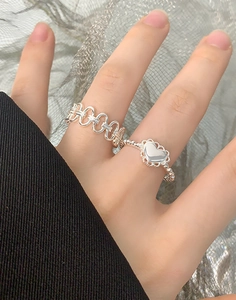 Close-up of S925 sterling silver chain ring and heart ring worn on model fingers