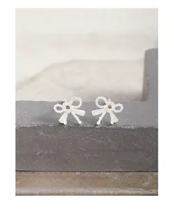 Vue macro des boucles d'oreilles nœud en argent S925 avec fleur en zircon jaune