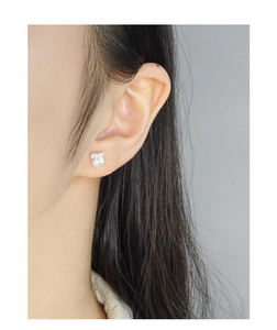 Silver bow knot pearl stud earrings worn by model showing elegant minimalist design