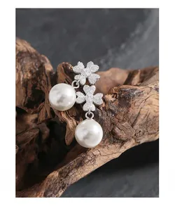 Detail of S925 silver leaf earrings with shimmering zircons and elegant white pearls