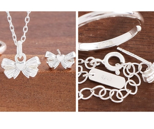Detailed view of S925 sterling silver bow jewelry set with hallmark stamps and polished finish