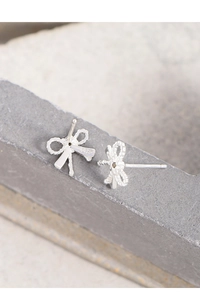 Vue détaillée des boucles d'oreilles nœud en argent S925 avec zircon sur fond de pierre