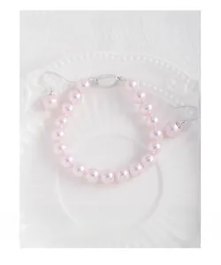 Détail de bijoux en perles roses comprenant un bracelet en argent et boucles d'oreilles