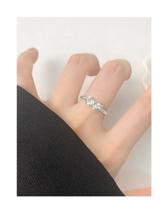 Close-up of minimalist S925 silver bow ring worn on finger with polished finish
