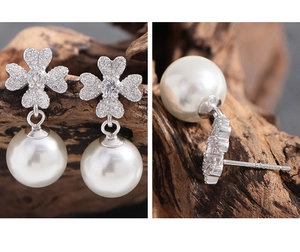Detail view of S925 sterling silver stamp on leaf zircon and pearl stud earrings