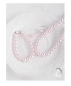 Detail of pink pearl necklace and earrings set displayed on a white ceramic plate