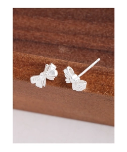 Macro view of S925 sterling silver bow knot earrings with detailed hallmark engraving