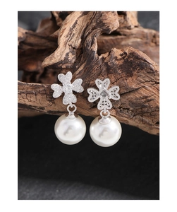 Detail of silver clover leaf stud earrings with zircon inlay and hanging white pearls