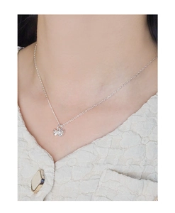 Silver bow necklace on model's neck showcasing the delicate chain and pendant