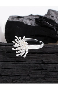 Macro detail of S925 sterling silver ring with fireworks flower design on charcoal base
