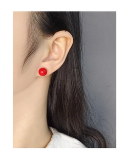 Nahaufnahme von minimalistischen 10mm roten Achat-Ohrsteckern, getragen am Ohrläppchen
