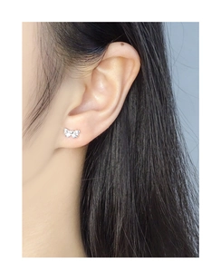 Close-up of S925 sterling silver bow stud earring worn on ear for elegant style