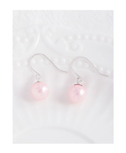 Macro view of cherry blossom pink pearl earrings with silver s925 hooks on a ceramic tray