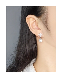 Close-up of S925 silver leaf earrings featuring clover zircon studs and white pearls
