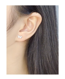 Macro shot of S925 sterling silver bow knot stud earring worn on a person ear