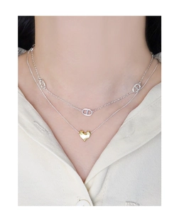 Close-up of double-layer S925 silver necklace with gold lava heart pendant on a model